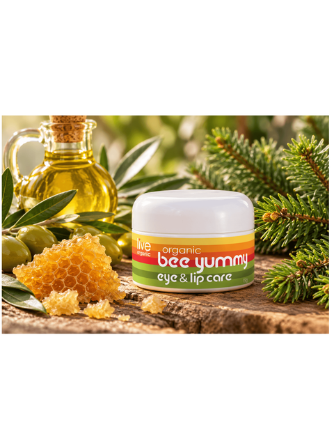 bee yummy eye and lip care, by live organic, placed on some wood next to beeswax and a balsam fir branch.