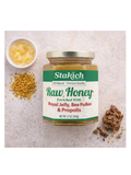 Jar of Stakich raw honey with ingredients on a textured surface