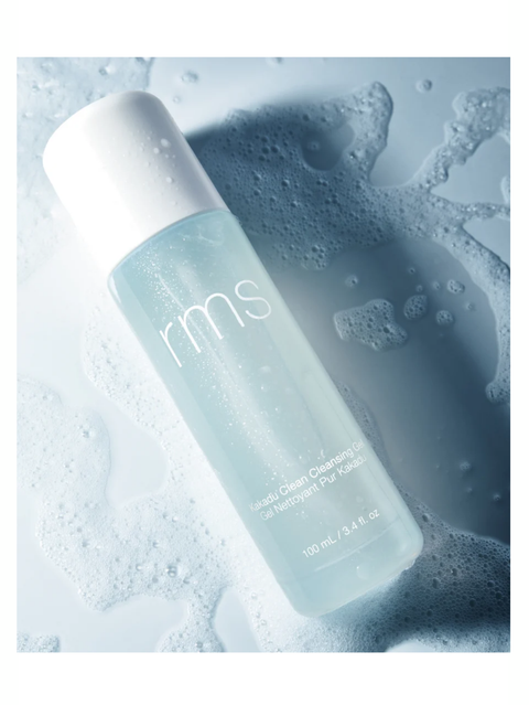 Kakadu Clean Cleansing Gel by RMS Beauty with a white cap on a textured blue background