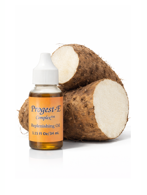 Progest-E Complex replenishing oil , by Kenogen, with two pieces of wild Yam root on a white background