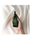 Hand holding a bottle labeled 'Toxin Binder' against a soft, neutral background