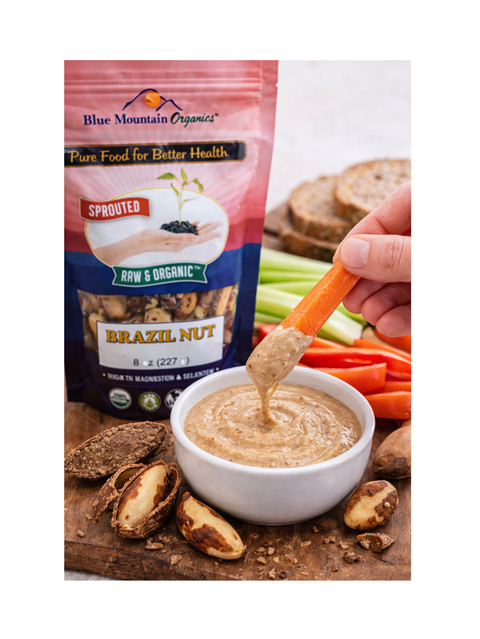 Blue Mountain Organics Brazil Nut product with a hand dipping a carrot into a bowl of dip.