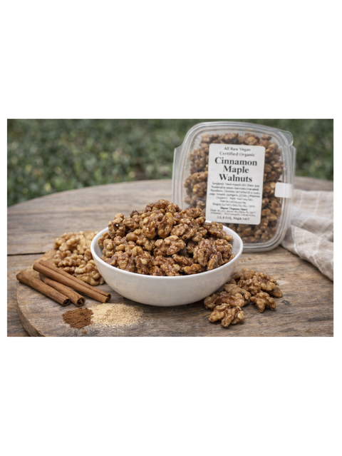Cinnamon maple walnuts in a bowl and packaging on a wooden surface with a natural background.