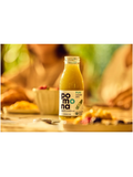 A bottle of Pomona Pure Cucumber Juice standing on a table in a warm, blurred dining setting with people in the background.