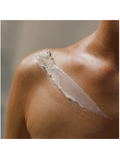 Close-up of a person's shoulder with Day Crème, 1oz, Moisturizing Day Cream, Dr. Alkaitis smear.