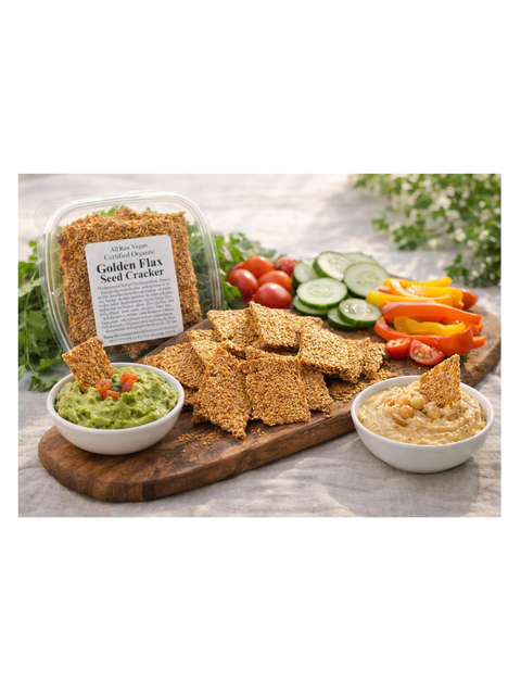 Golden Flax Crackers, 4oz, Glaser Organic Farms on a wooden board with dips and vegetables.