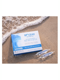 Bioccean isotonic 0.9 Ampoules packaging on a beach with ocean waves.