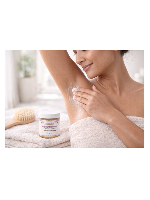 Woman applying Keeping Abreast Of It, 4oz, Simply Divine Botanicals to her armpit with a jar of cream and towel in the background.
