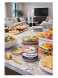 Jar of macadamia nut butter on a table with snacks and candles in a living room setting
