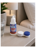 A bottle of Rich's MSM Water contact lens solution next to a contact lens case on a light wood table in a cozy bedroom setting.