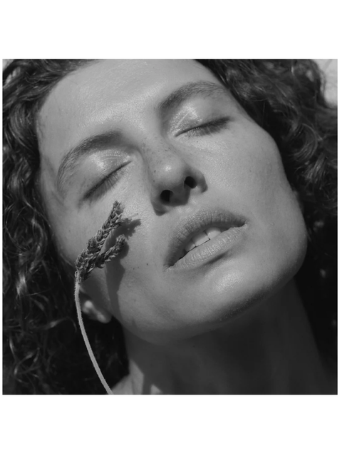 Close-up of a person with a plant on their face, black and white photo