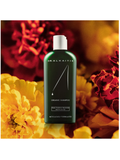 Dr. Alkaitis organic shampoo bottle with flowers in the background