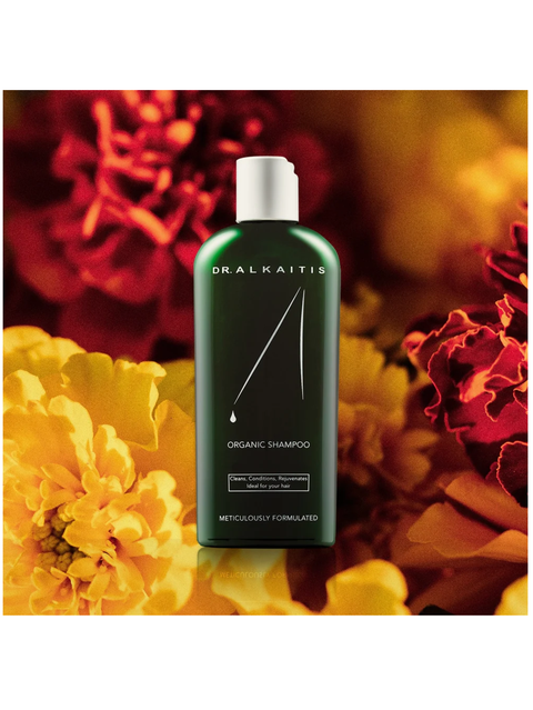 Dr. Alkaitis organic shampoo bottle with flowers in the background