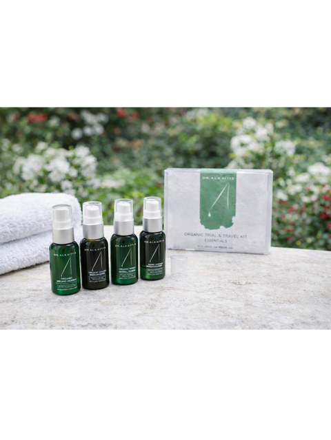 Set of Organic Skin Care Travel Kit, Dr Alkaitis on a surface with a blurred natural background