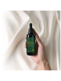 Hand holding Paratrex II, Advanced Detox Support, 2oz, by Global Healing against a beige fabric background