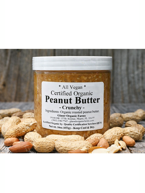Jar of organic crunchy peanut butter with peanuts around on a wooden surface