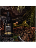 Bottle of Pine Pollen Gold on a wooden background with pine needles.