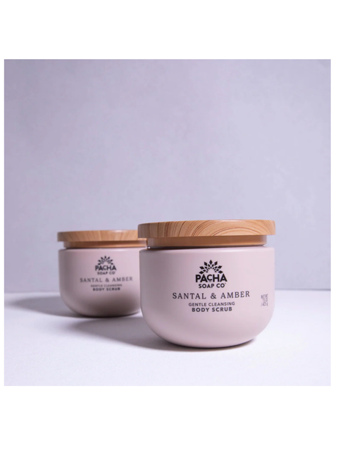 Two pale pink body scrub jars with light wood lids on a white surface against a light gray background. The front jar reads 'PACHA SOAP CO.