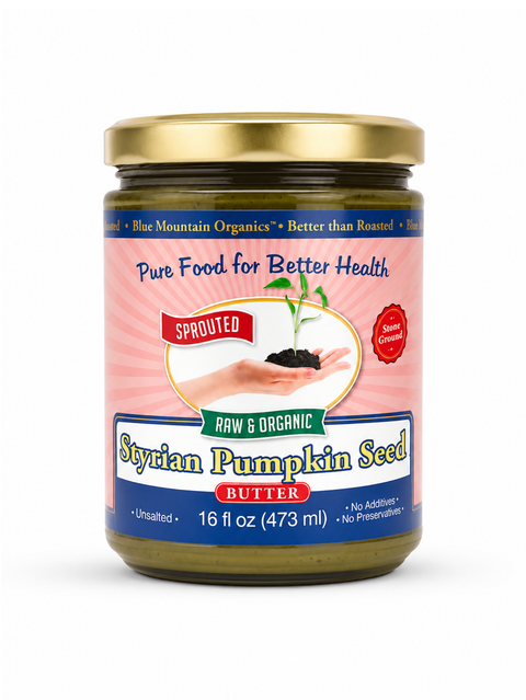 A jar of Blue Mountain Organics Sprouted Styrian Pumpkin Seed Butter, featuring a pink and blue label with a gold lid, set against a plain white background.