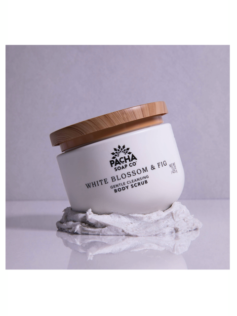 White body scrub container with wooden lid on a light gray background